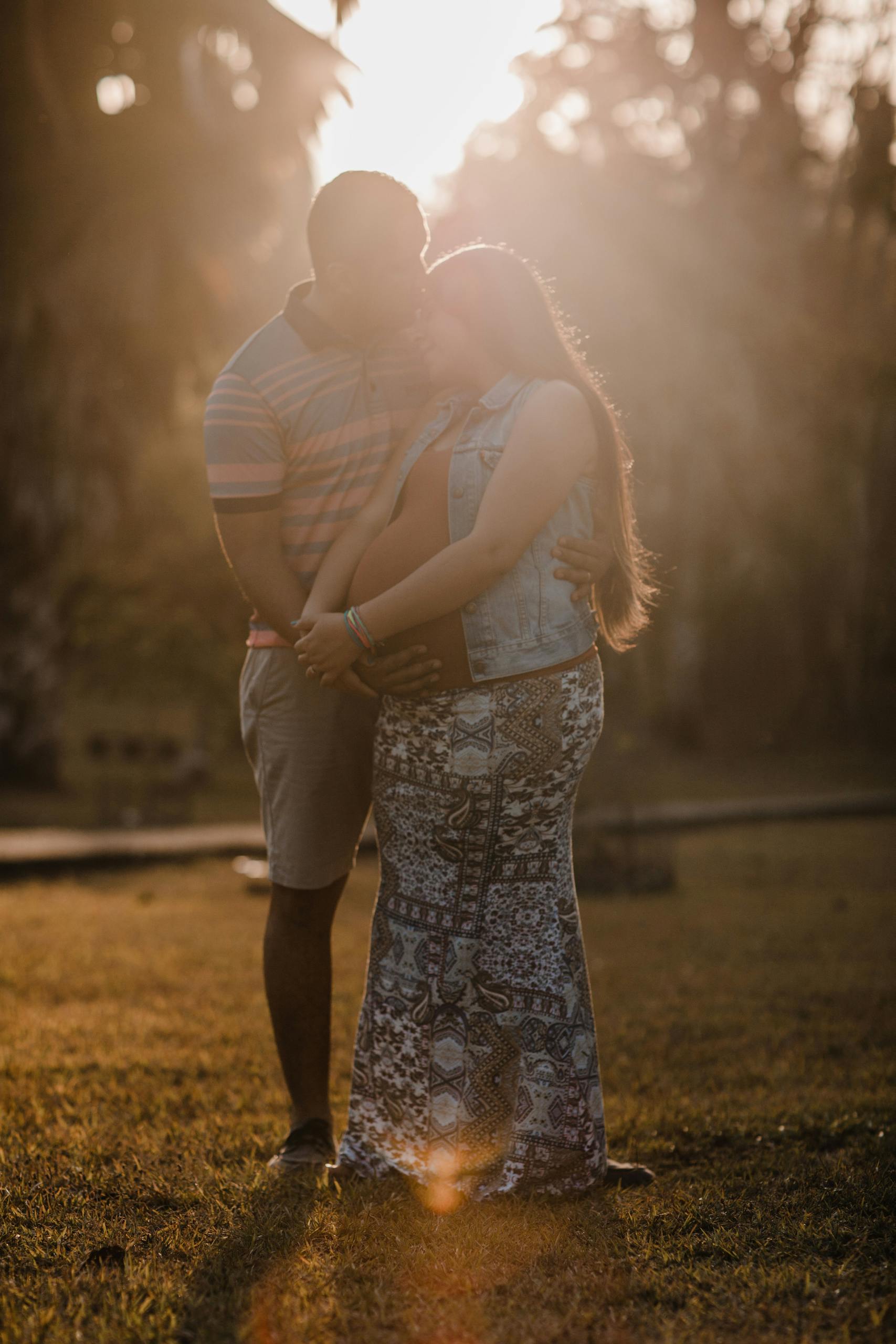 A loving couple cherishing their pregnancy under the warm sun in a Panama park.