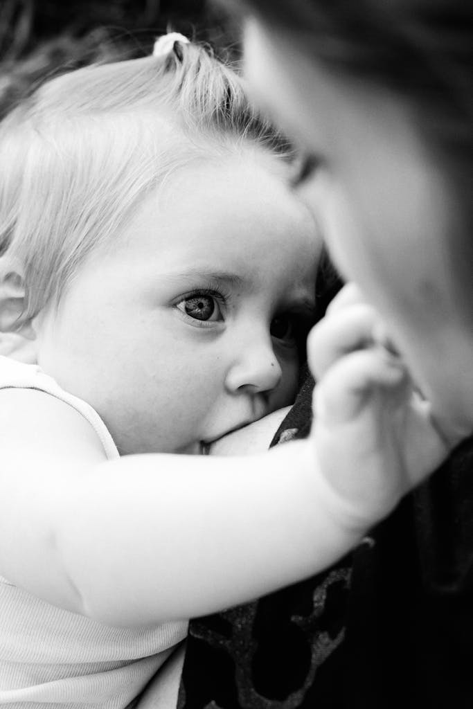 Tender black and white image of a mother breastfeeding her baby.